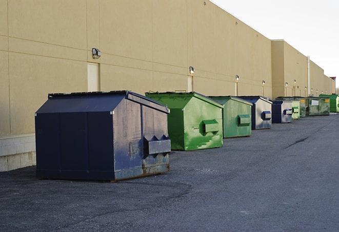 a group of dumpsters lined up along the street ready for use in a large-scale construction project in Chestnut Hill, MA